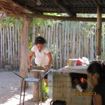 Woman grinding corn for tortillas